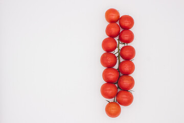 Cherry tomatoes on branch stand on white background
