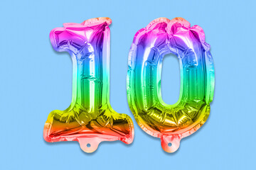 Rainbow foil balloon number, digit ten on a blue background. Birthday greeting card with inscription 10. Anniversary concept. Top view. Numerical digit. Celebration event, template.