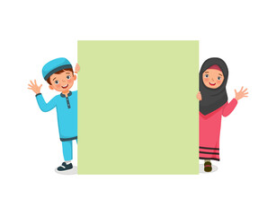 happy Muslim kids little boy and girl peeking from behind blank billboard smiling and waving hands showing copyspace for advertising and announcement messages