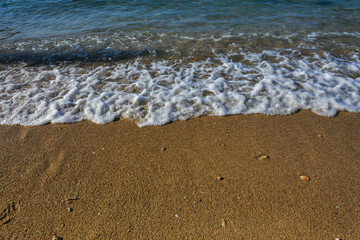 sea waves produce foam on the beach