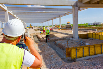 Civil engineer, geodesist is working with total station on a building site