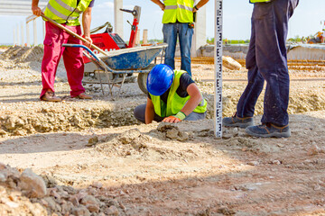Worker set up right measures in square trench