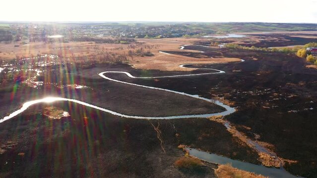 Burnt dry grass in the nature reserve of the river Seret, from a bird's eye view. Filmed in UHD 4k video.