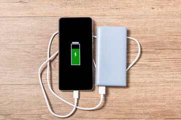 Smartphone Charging with a Power Bank Through Spiral USB Cable on table