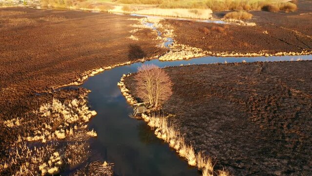 Burnt dry grass in the nature reserve of the river Seret, from a bird's eye view. Filmed in UHD 4k video.