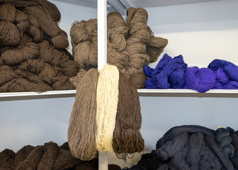 wool yarn threads, colored yarn skeins arranged on shelves, knitting as a hobby