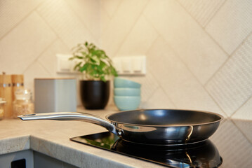 Steel frying pan in the kitchen on electric induction hob, Modern kitchen appliance