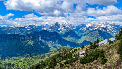 Obraz premium Panoramic view in spring from Frauenkogel on mountain peaks in the Karawanks and Julian Alps, Carinthia, Austria. Border with Slovenia. Triglav National Park. Jesenice in the Upper Drava valley. Hike