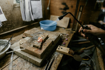 Jeweler at work in jewelry. Desktop for craft jewelry making with professional tools. Close up view of tools. Silver jewelry. 