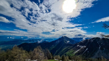 Fototapeta premium Panoramic view near Frauenkogel on the mountain peaks in the Karawanks, Carinthia, Austria. Borders Austria, Slovenia, Italy. Triglav National Park. Looking on mount Kahlkogel (Golica). Forest valley