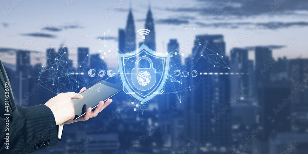 Poster close up and side view of businessman hands using tablet with glowing shield hologram on blurry city