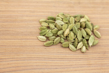 Heap of cardamom on wooden background