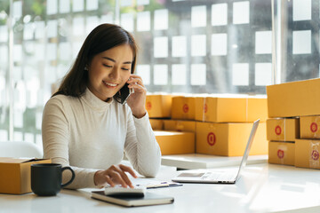 Portrait young attractive asia female owner startup business look at camera work happy with box at...