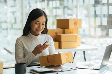 Portrait young attractive asia female owner startup business look at camera work happy with box at home prepare parcel delivery in sme supply chain, procurement, omnichannel commerce online concept.
