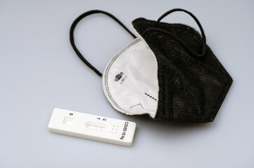 Closeup of express antigen covid test, negative result, black ffp2 mask in light background