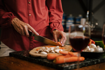 Caucasian senior female chopping vegetables in kitchen