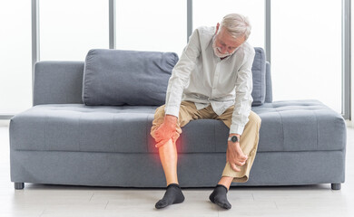 Health care and problem concept Uhappy senior man suffering from knee ache at home. Knee joint injury. Gout. Rheumatoid. Arthritis. Osteoporosis
 - obrazy, fototapety, plakaty