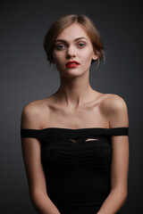 Fototapeta premium expressive studio portrait of a young attractive girl in a black dress
