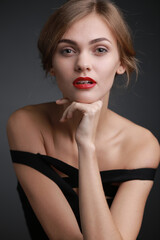 Fototapeta premium expressive studio portrait of a young attractive girl in a black dress