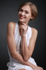 Fototapeta premium expressive studio portrait of a young attractive girl in a white dress