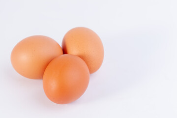 Three eggs are placed on a white background with free space on right