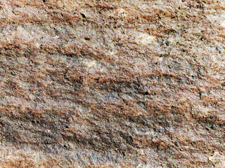 Red stone relief texture pattern close-up.