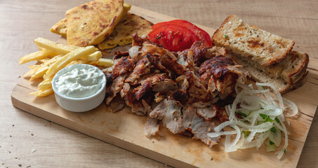 Gyro Greek sliced meat, ethnic dish, pita bread, tzatziki yogurt on wooden table, close up view