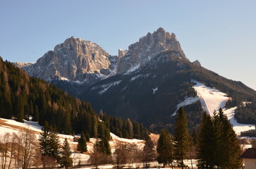 Photos of the snowcapped Dolomites during a winter trip and the small villages in the mountain valleys on a sunny, cold day