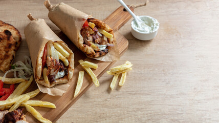 Gyro pita Shawarma wrap on wood table. Greek food with slice cut meat, overhead
