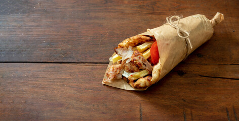Gyro pita Shawarma wrap on wood table. Greek food with slice cut meat, overhead - obrazy, fototapety, plakaty