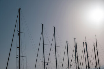 Yacht mast top with rope in row, clear blue sky background. Destination Greece.