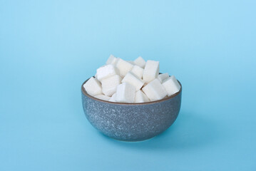 Fototapeta na wymiar Sugar in a bowl on a blue background