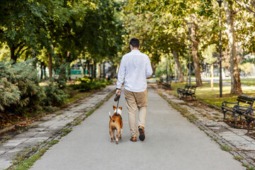 A man with the dog in a park.