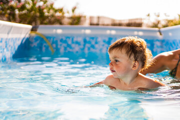 Little girl swimming in a swimming pool in house