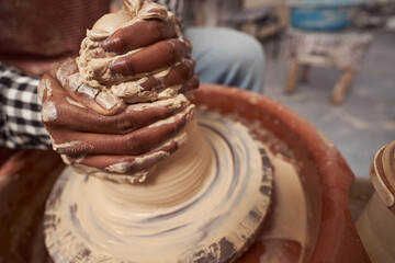 Skilled craft artist throwing pottery in his studio - obrazy, fototapety, plakaty