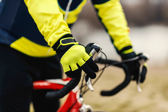 Close up of a bicyclist's hands holding a handlebars.