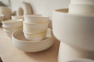 Round ceramic dish and teabowls in pottery studio - obrazy, fototapety, plakaty