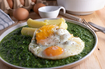 Creamed spinach with fried eggs and boiled potatoes