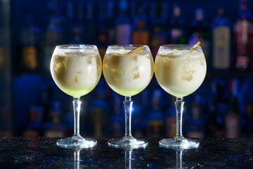 line of yellow refreshing cocktails on a bar desk