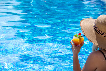 Fototapeta na wymiar girl drinks a cocktail in the pool.