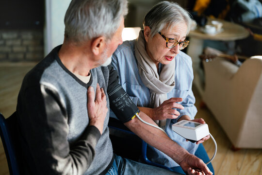 Senior couple at home measuring blood pressure. Home monitoring people healthcare concept