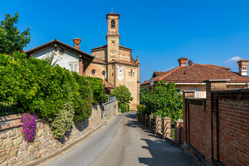 Fototapeta na wymiar Narrow street and old church in Guarene, Italy.