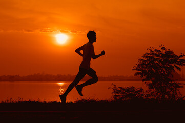 young male runner while practicing running On the road around the park around Thawatchai Reservoir Roi Et Province