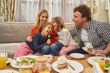 Portrait of smiling parents sitting with daughters