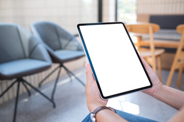 Mockup image of a woman holding digital tablet with blank white desktop screen in cafe