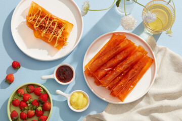 rice paper roll decorated strawberry tamarind sauce and butter in white dish and blue background for food advertising 