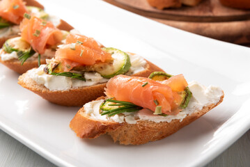 Deliziosi crostini conditi con formaggio, zucchine e salmone affumicato, antipasti italiani 