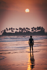 Fototapeta premium woman silhouette walking on sunset beach