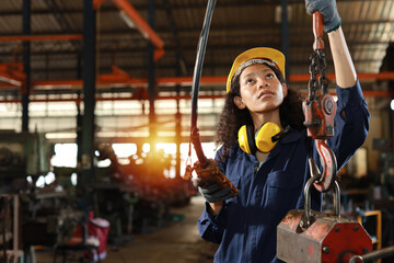 Technician engineer or worker woman in protective uniform with safety hardhat standing and...