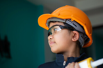 Asian boy dressed as a craftsman and holding tools